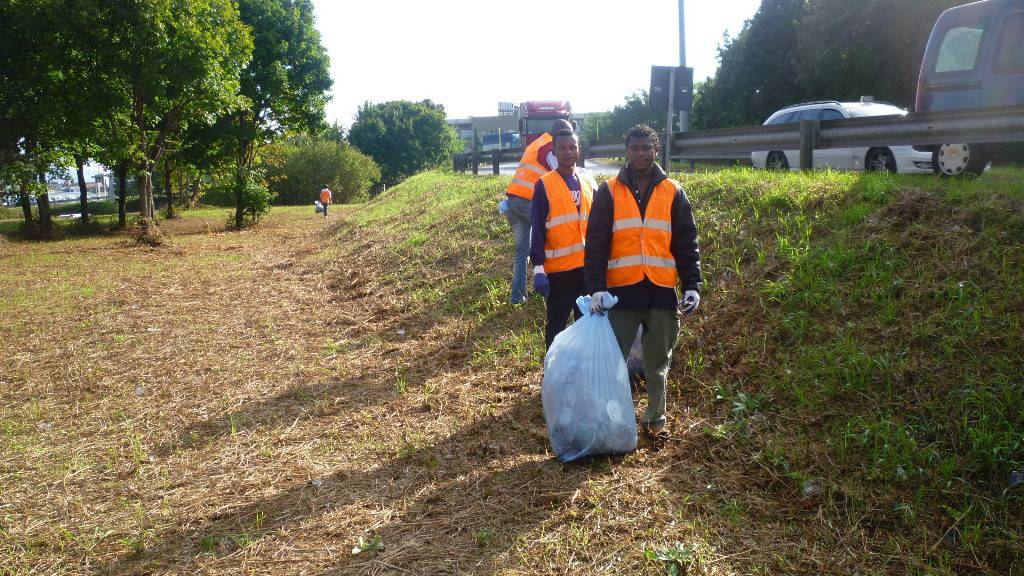 Immigrati puliscono la rotonda dell'autostrada